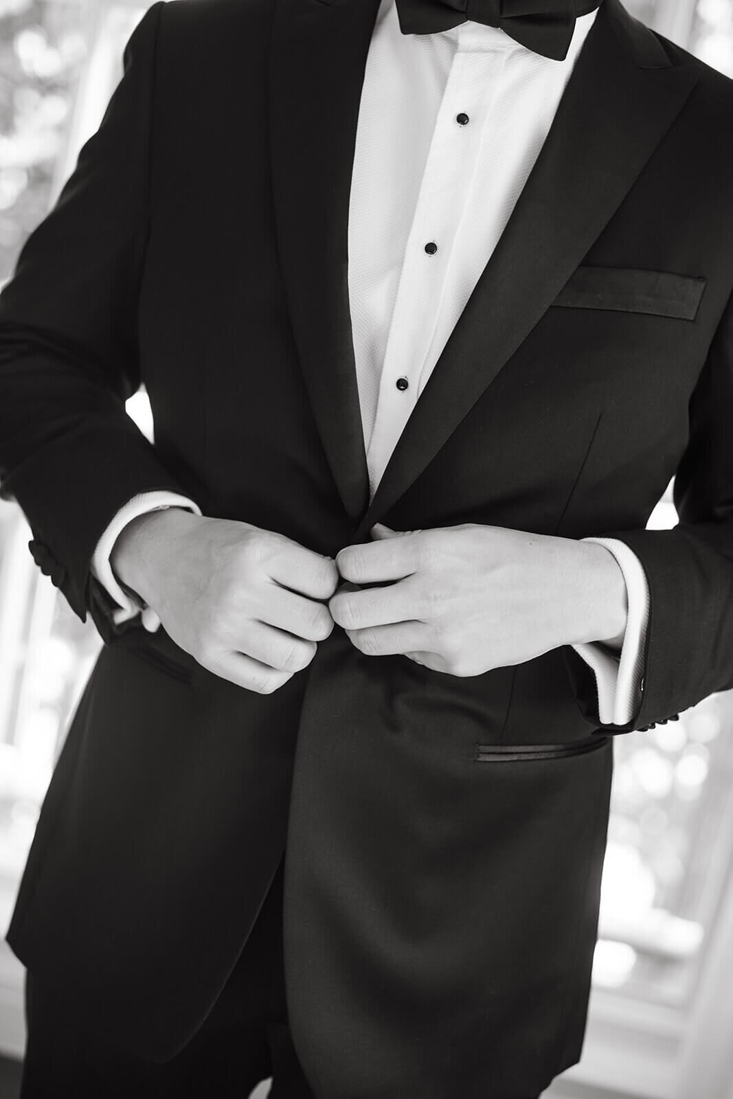 Close-up of the groom at St. Regis Aspen, adjusting his tie in a refined, elegant setting before the wedding ceremony.