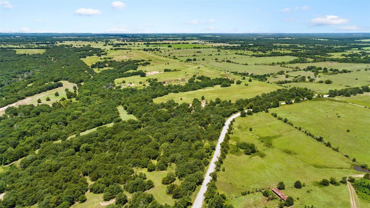 Aerial view of 55-acre property with mature post oaks in Saint Jo, TX