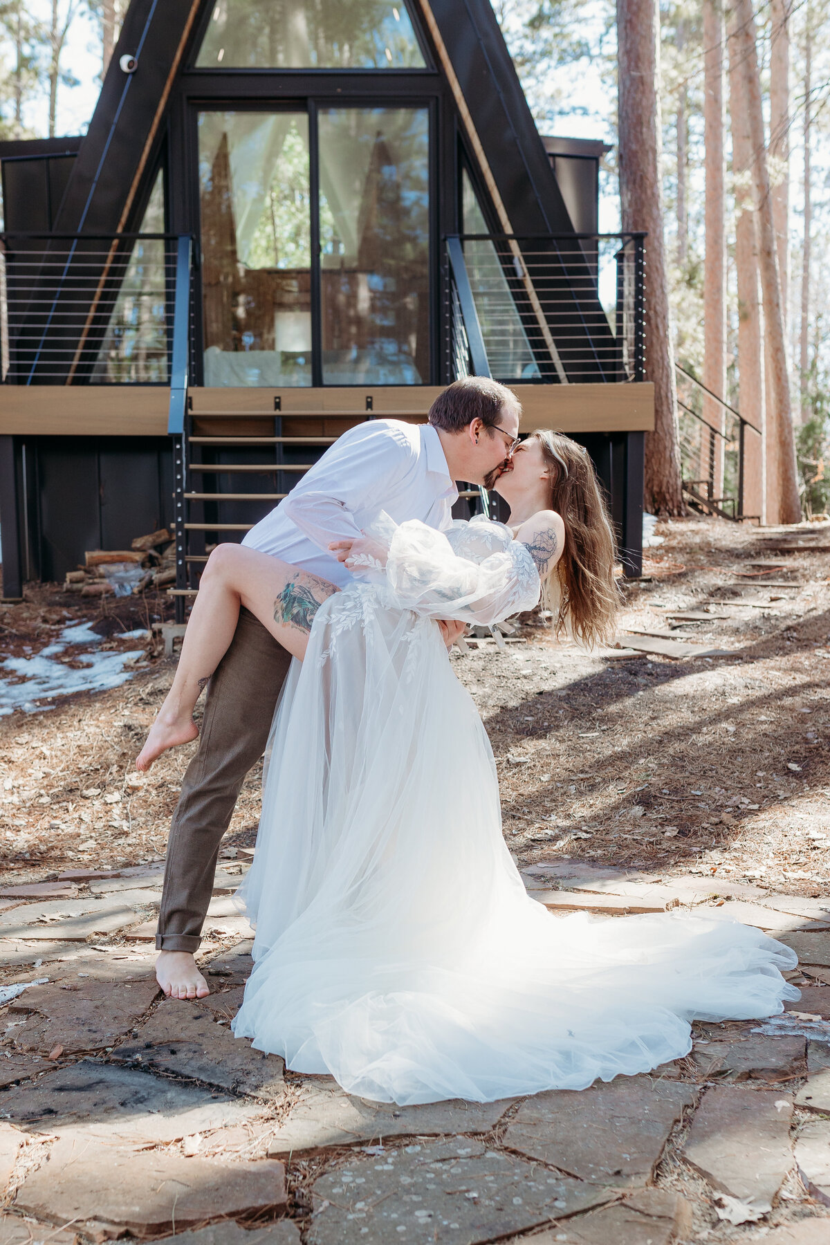 During their elopement, the couple dips in front of their A-frame cabin venue.
