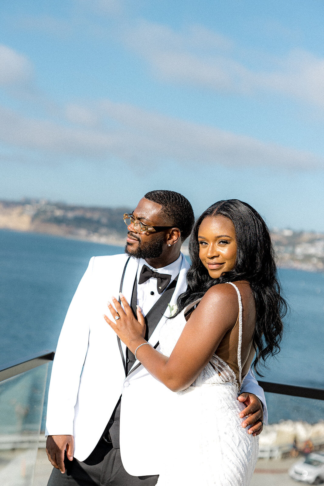 Bride and groom smiling in San Diego with ocean in the back