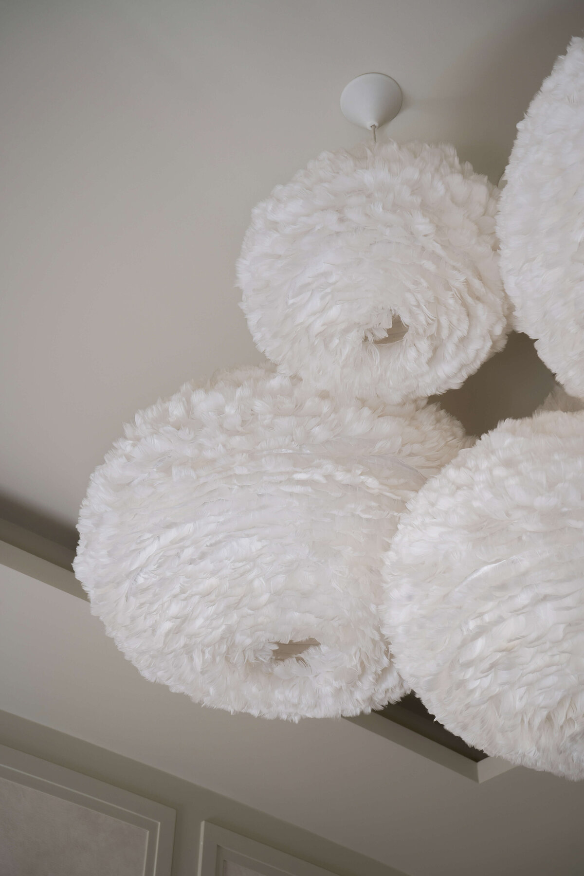 Four white feathery sphere pendant lights.