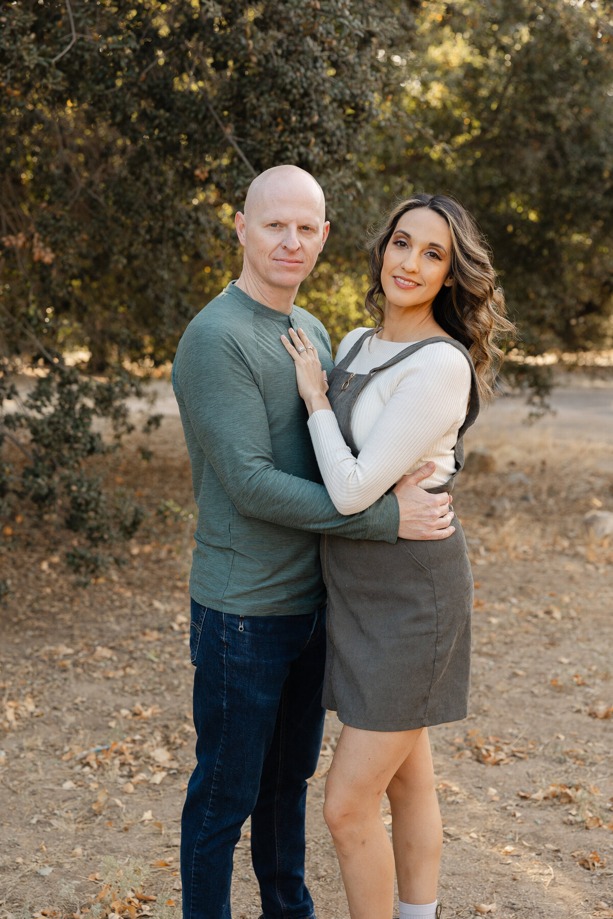 Couple embracing outdoors during fall family photoshoot. Photographed by Yucaipa family photographer Kaitlyn Dawn Photography.