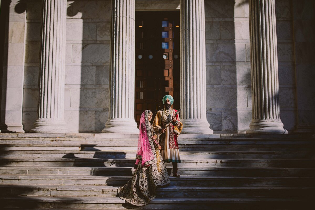 Sikh bride and groom standing on the steps at a white building with columns at princeton university nj