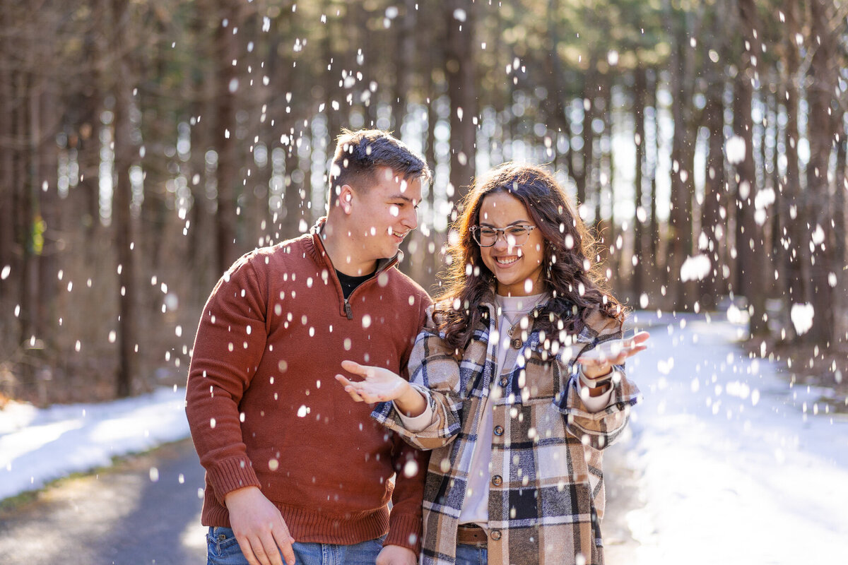 Engaged couple tosses up some snow and laugh together - Walnut Woods Tall Pines Groveport, Ohio