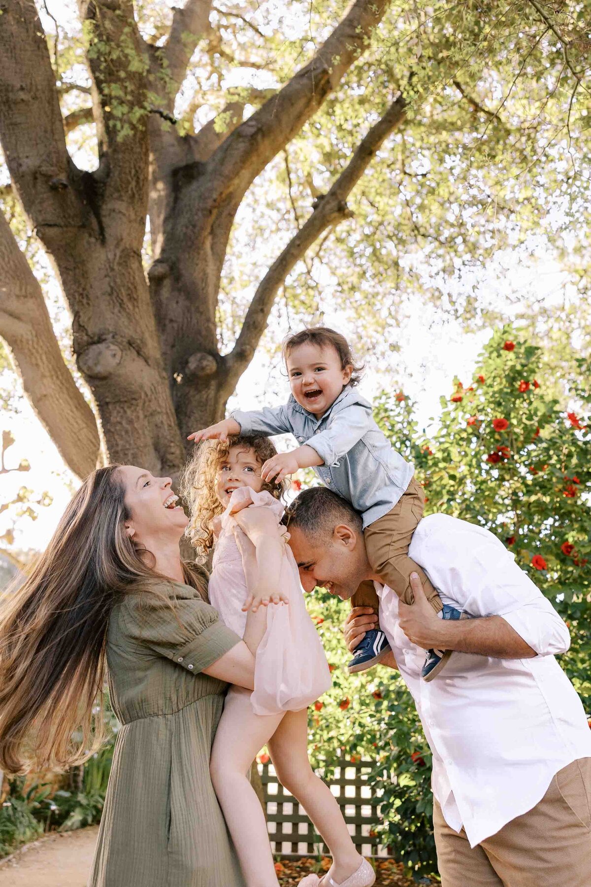 family having tickle fight at gamble garden palo alto