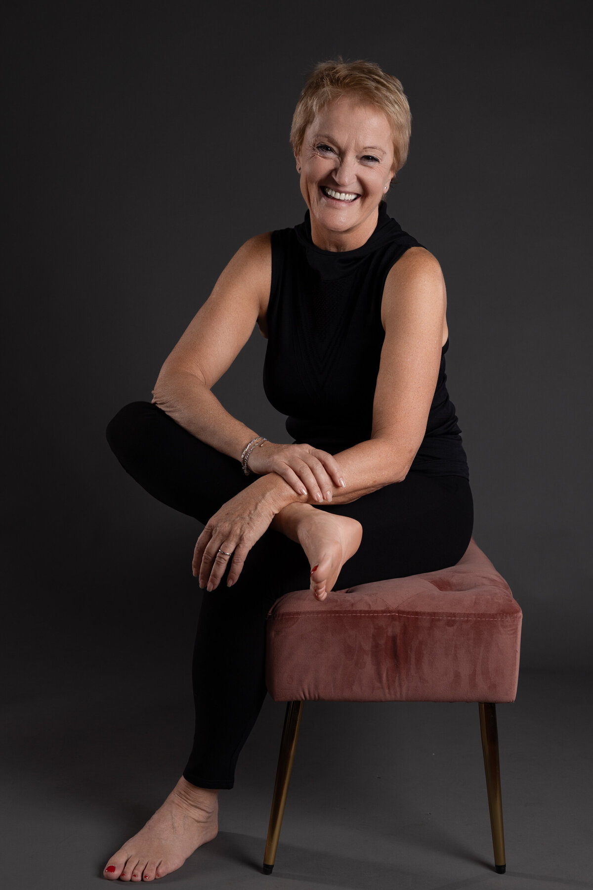 Femme assise en tenue décontractée Photo de studio sur fond gris