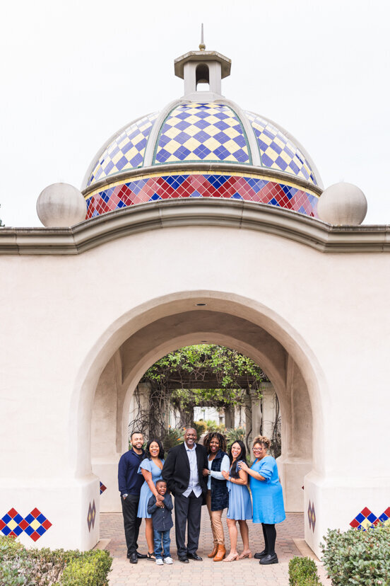 family standing under arch at balboa park san diego