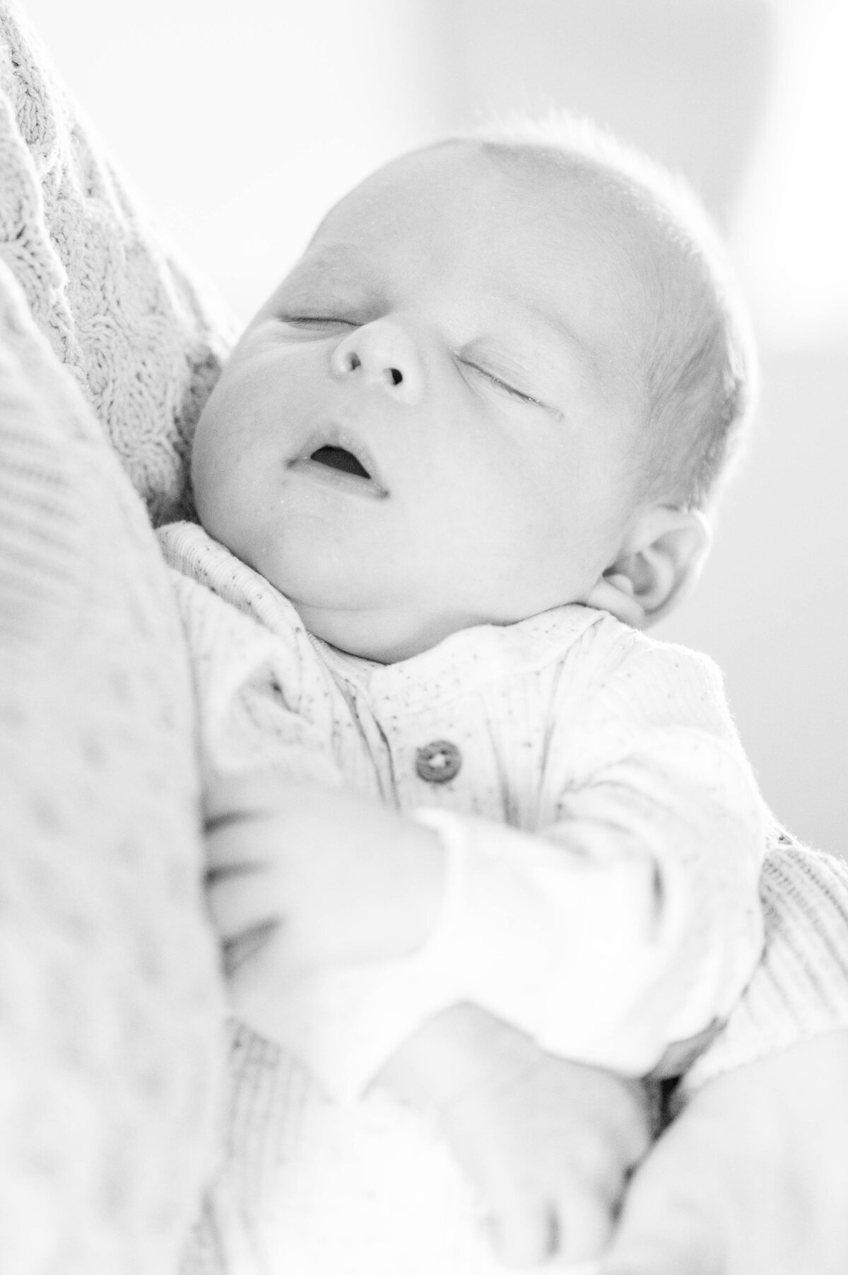 Black and white image of newborn sleeping taken in Sutton, MA 