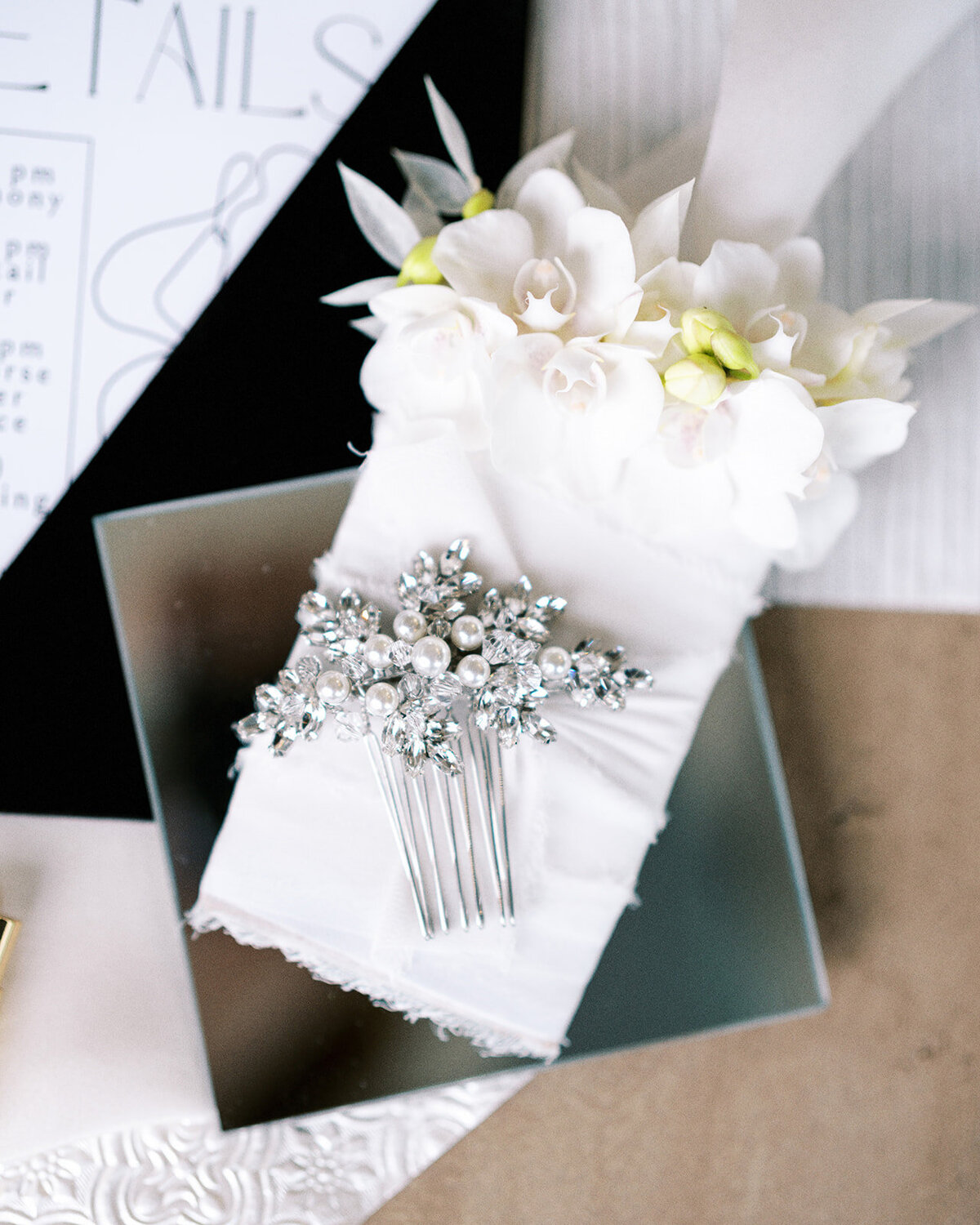 A wedding details flat lay with a hair comb at a styled photography shoot.