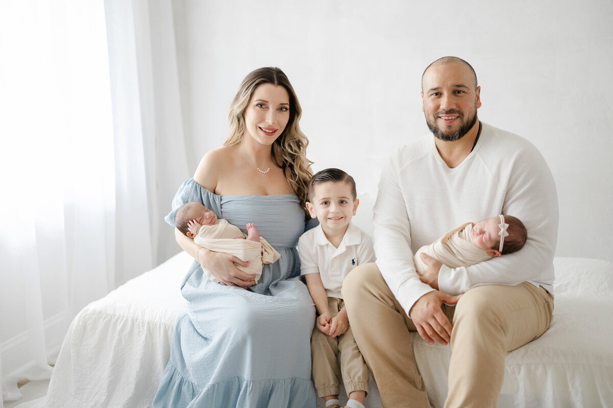 Newborn twins wrapped in neutral tones during luxury Tampa studio session with soft natural light