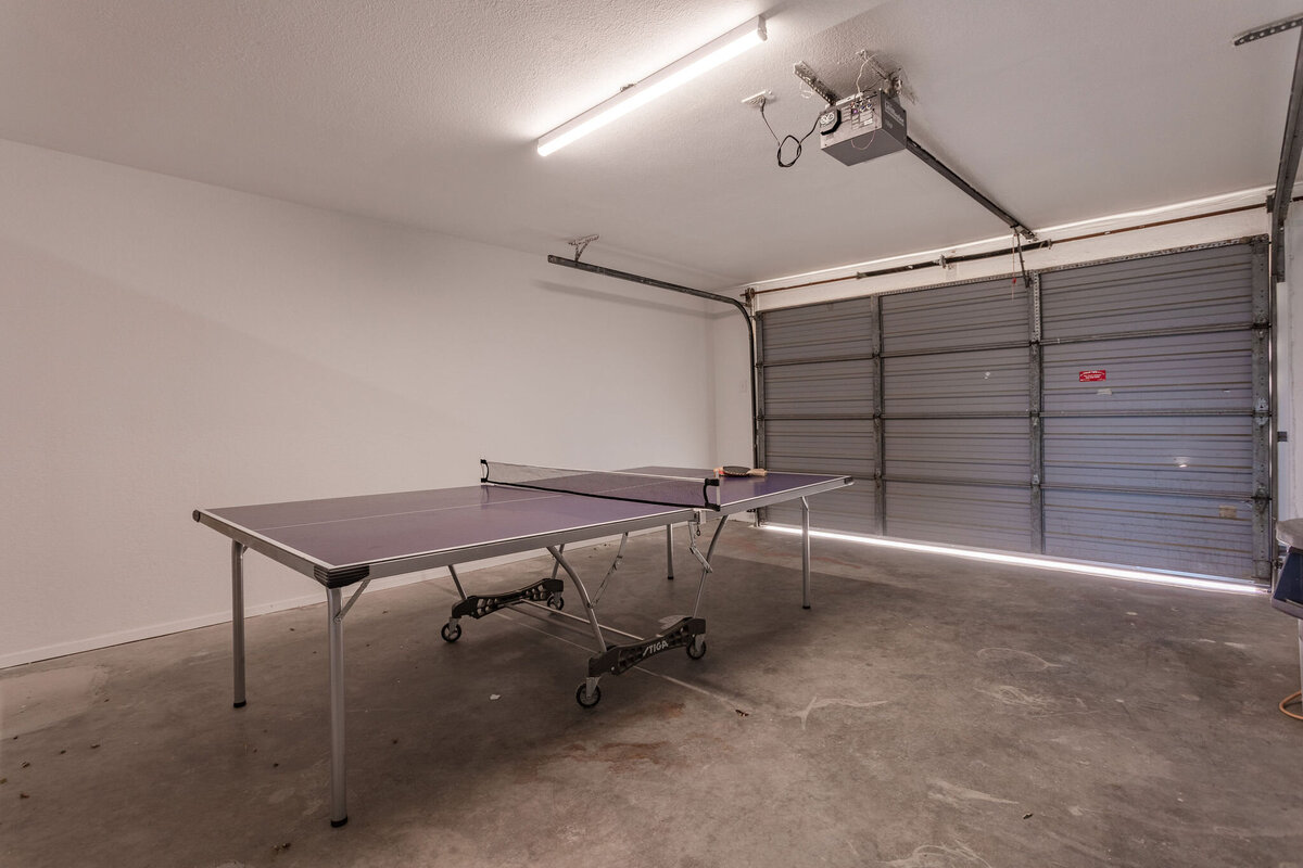 Ping pong table in the garage of this 2-bedroom, 2-bathroom lakeside vacation rental home for 6 guests on Tradinghouse Lake with privacy access to a fishing dock and boat launch pad, ping pong table, gazebo, free wifi and free parking in Waco, TX.