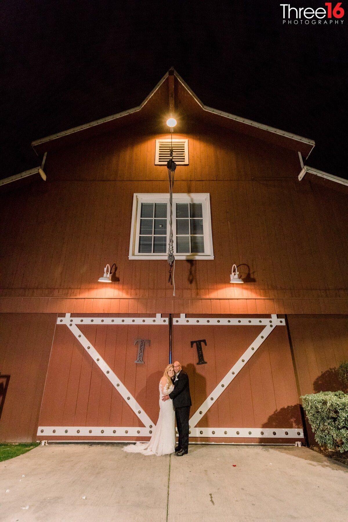 Bride and Groom pose outside the barn doors