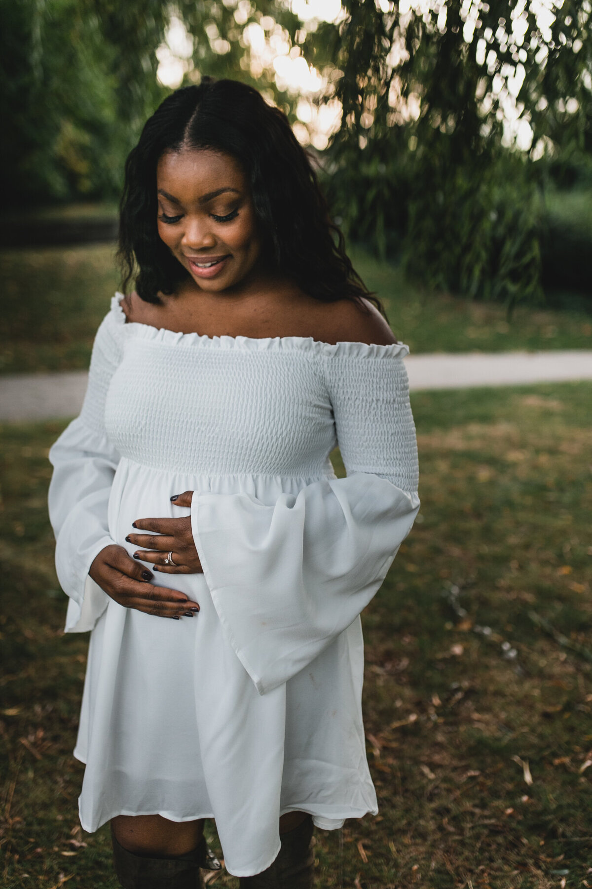 Maternity shot with soon to be mom wearing white dress.