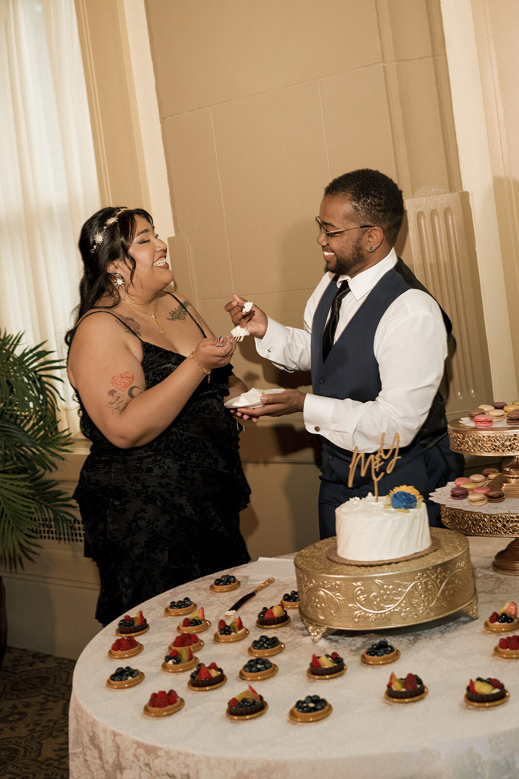 happy couple smiling wedding cake cutting
