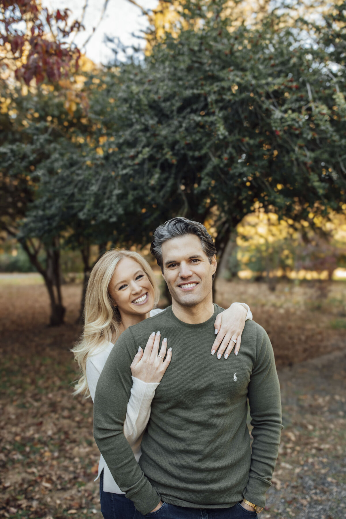 Couple with sunlight filtering through trees during engagement shoot at Cross Estate Gardens in Bernardsville Somerset County New Jersey