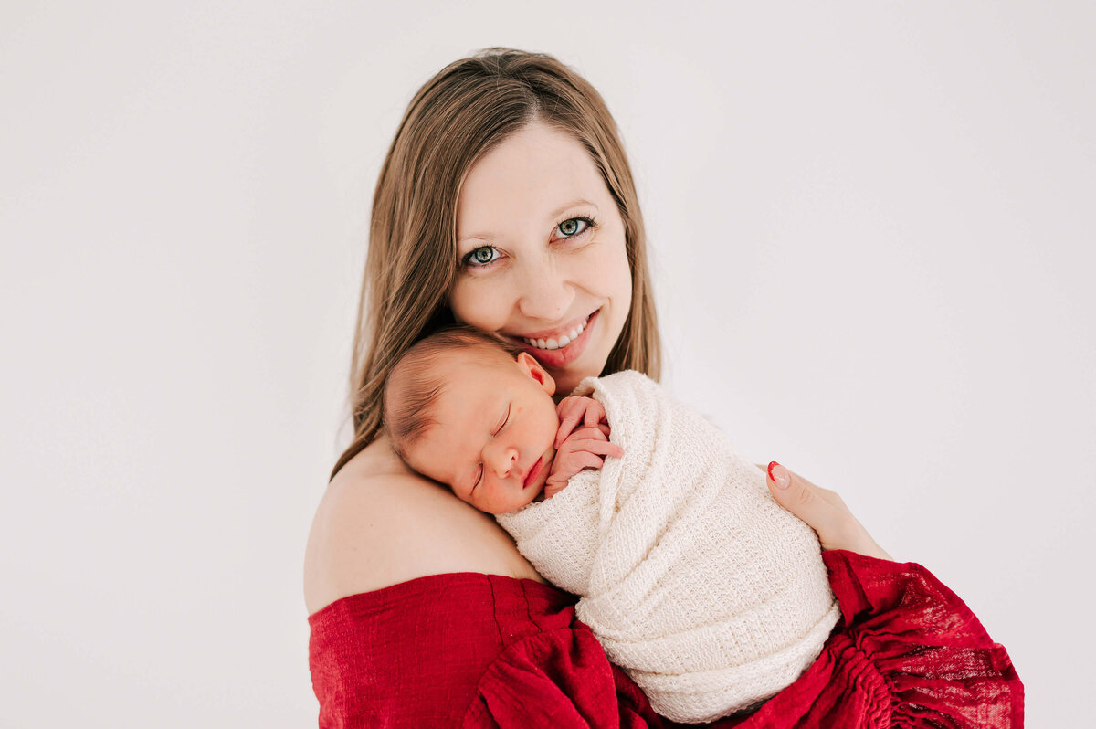 newborn picture in Springfield MO of mom smiling with baby sleeping on shoulder