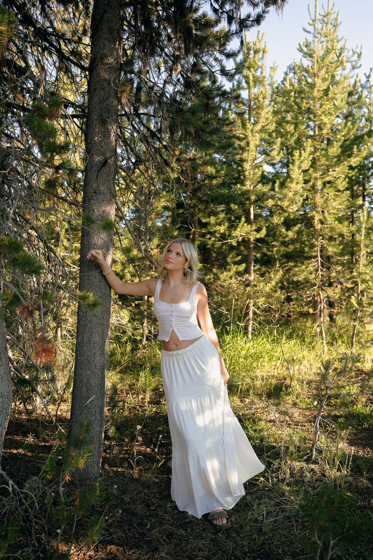 Senior Portrait Sitting in Meadow of Wild Daisies During Golden Hour in Oregon Countryside