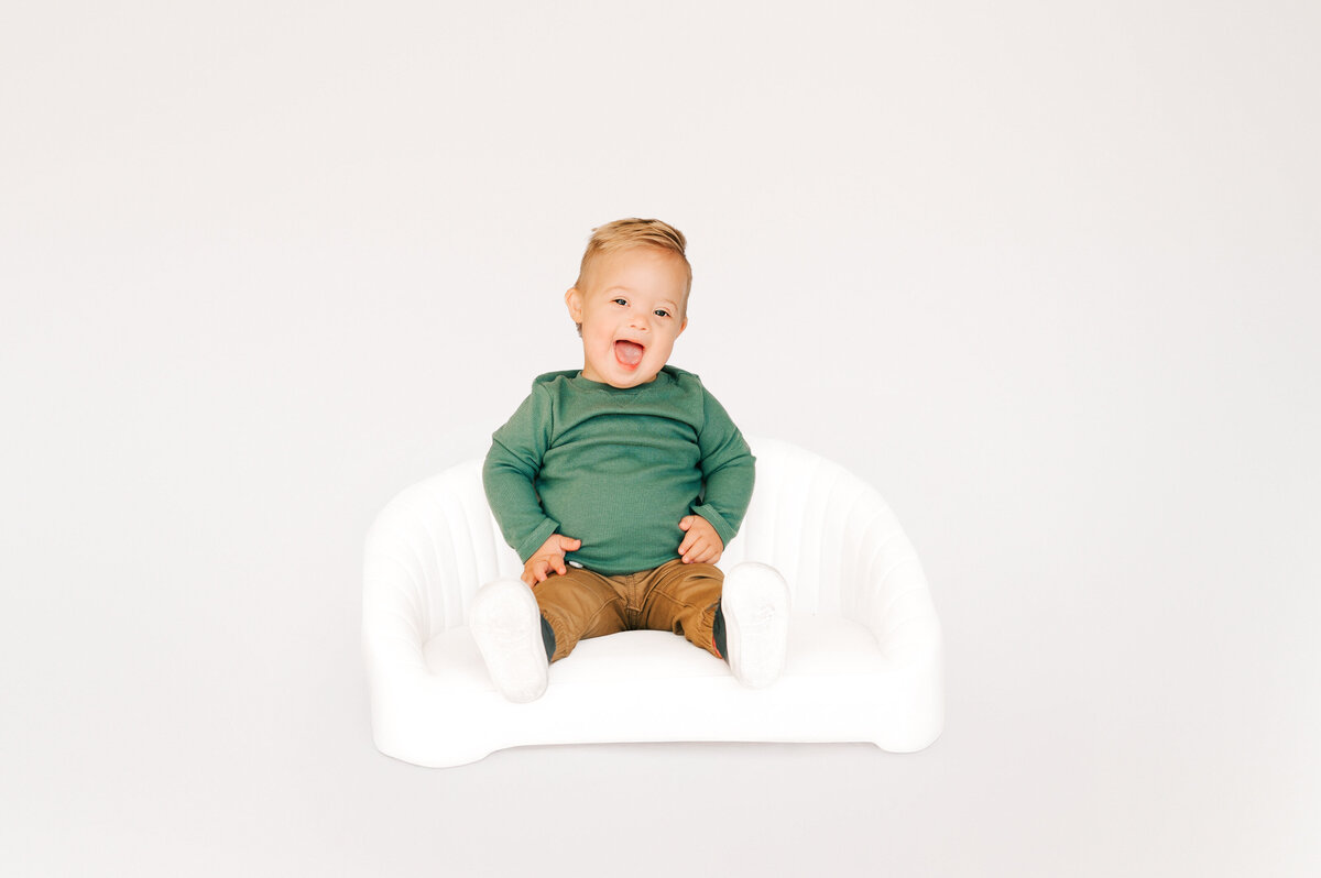 boy laughing on couch in Springfield MO kids photography studio 