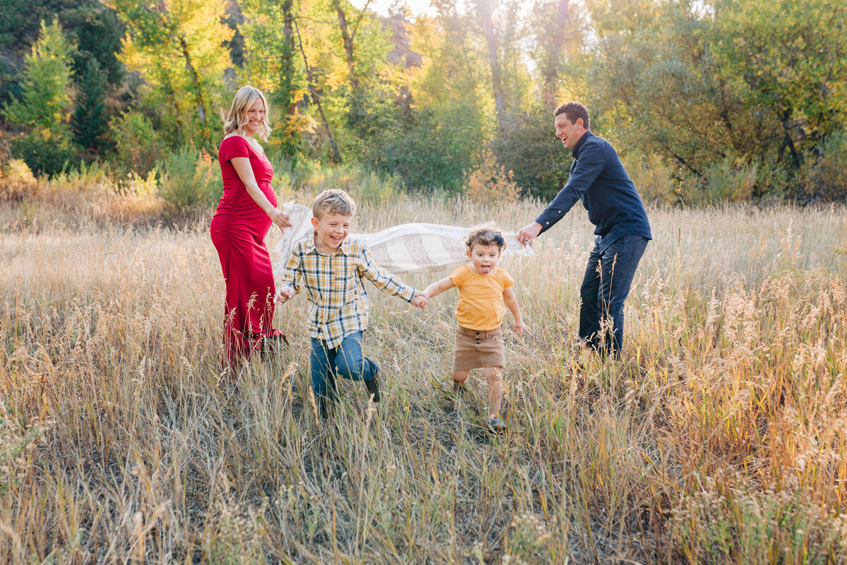 family running in a field for family photos in Oreogn