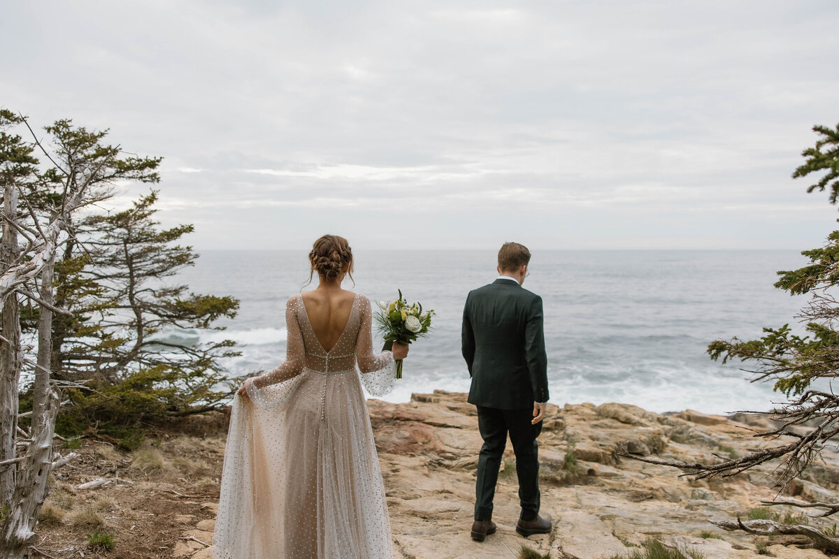 A couple walks onto otter cliffs of acadia to read vows