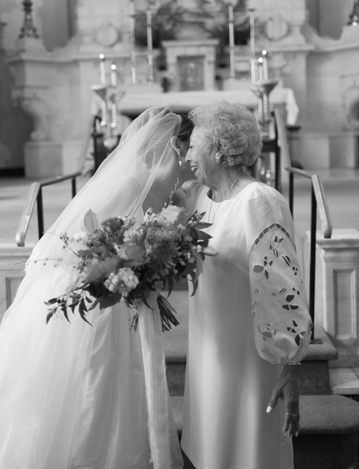 A bride laughs with her grandmother during wedding photos at St. Peter and Paul Church, Detroit