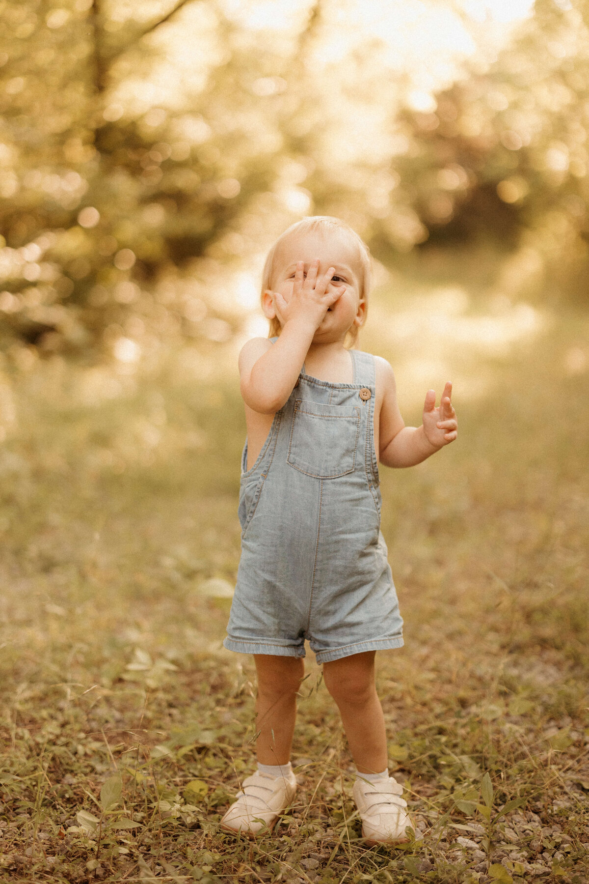 Parents swinging young child between them in grassy field in nashville tn
