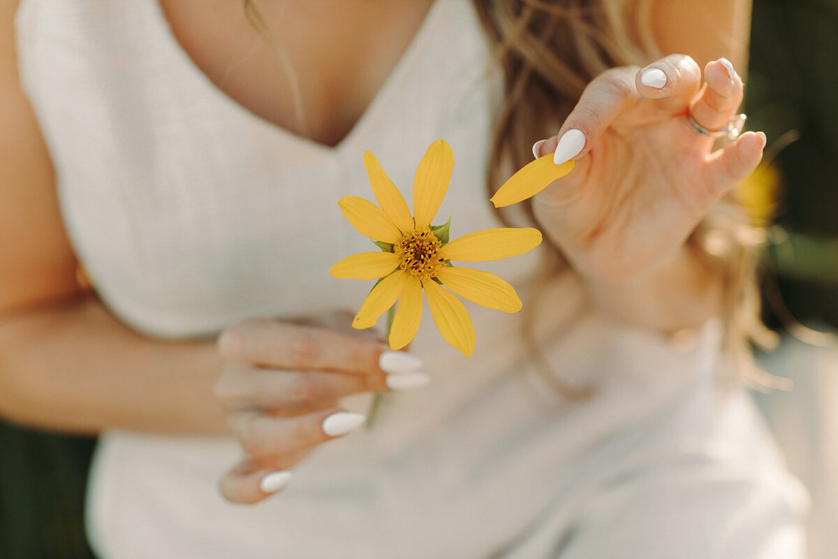 Utah Family Photographer captures woman holding a yellow flower during headshots