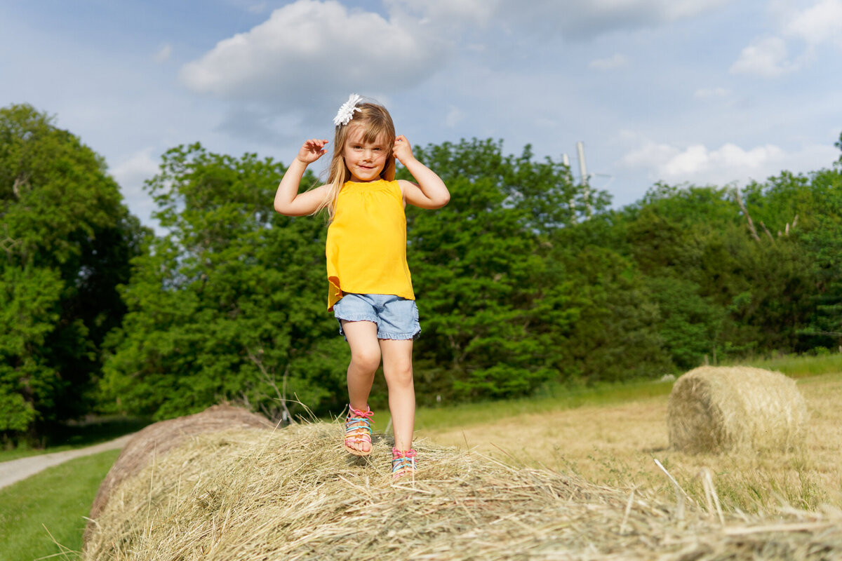 girl on hay bales outdoor daytime portrait