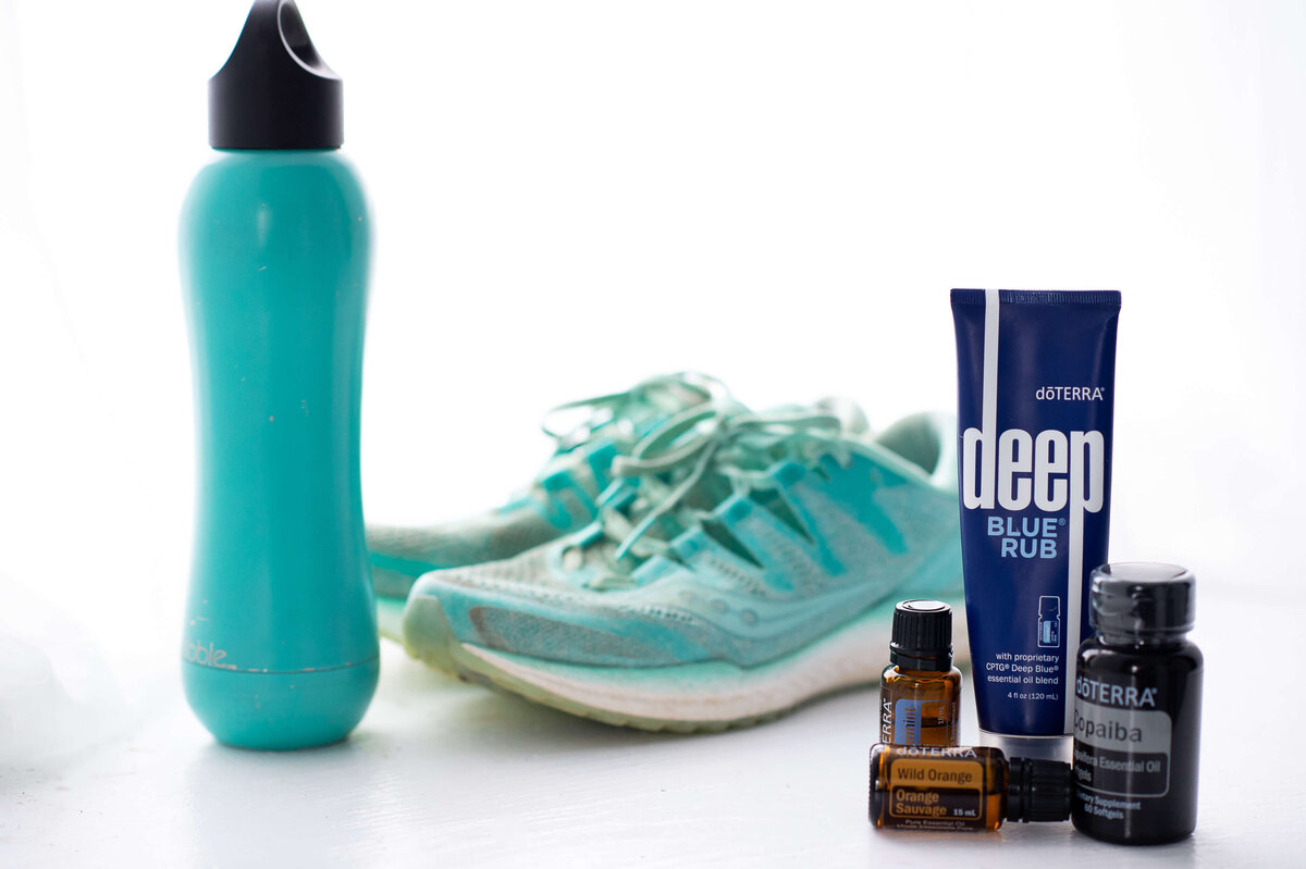 Ottawa brand photos showing a pair of turquoise running shoes beside a water bottle and DoTerra essential oils that are good for a post run workout