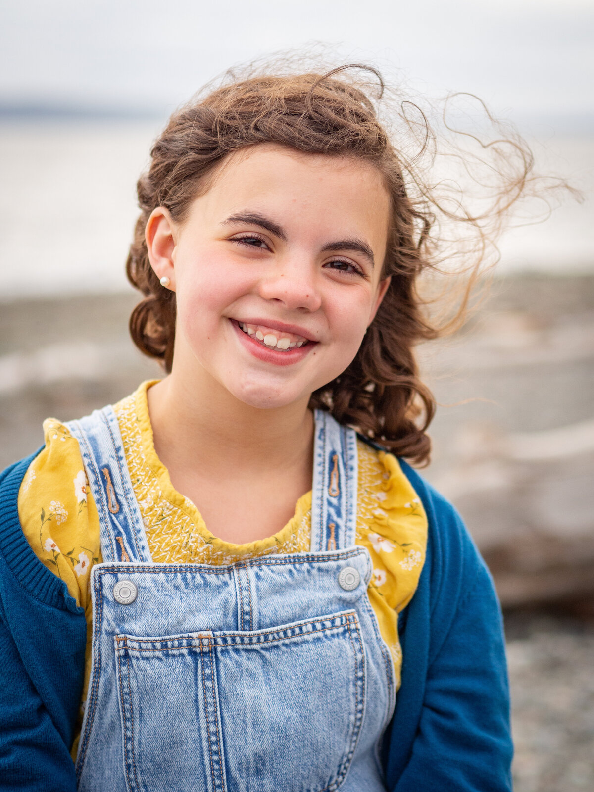Portrait of a child at the beach with the wind blowing her hair.