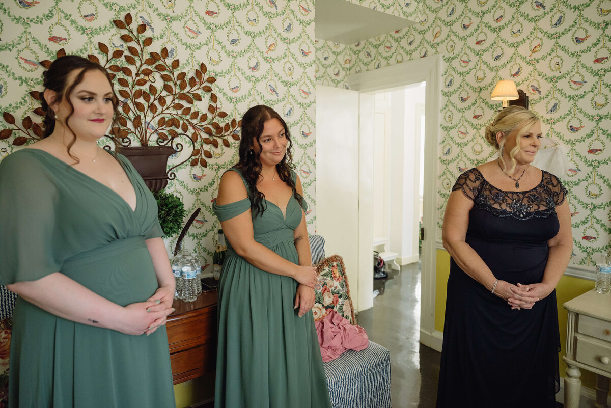 Virginia wedding photographer captures candid wedding photos in the bridal suite with bridesmaids and matron of honor watching the bride