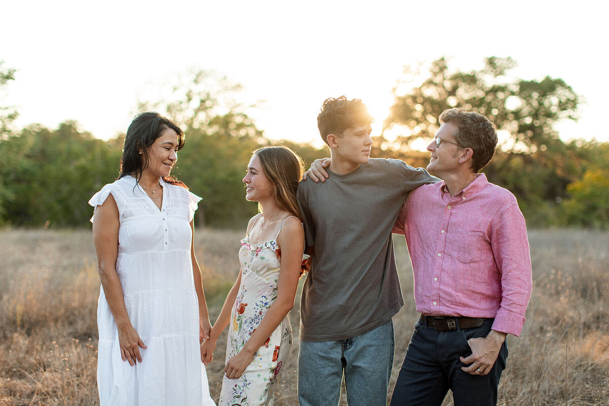 Family portrait session in field with exceptional lighting - Sara James San Antonio photographer creates radiant family images using premium natural light techniques in picturesque Texas countryside locations
