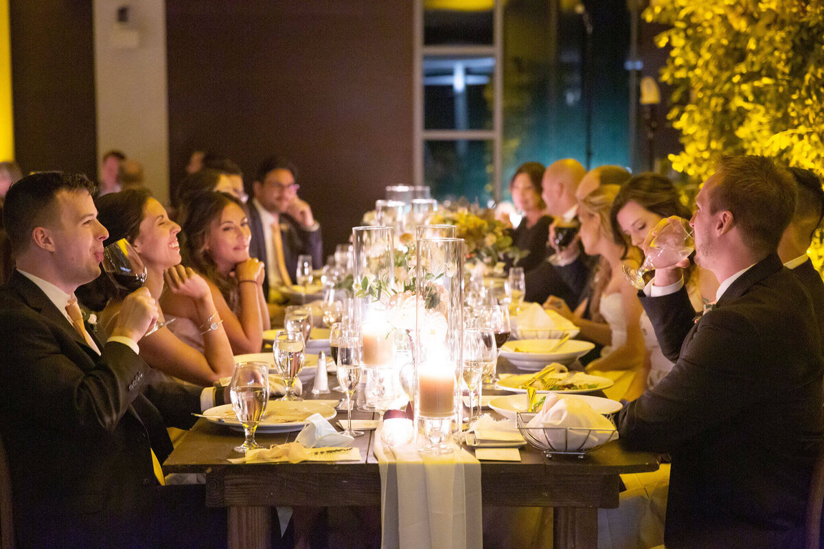 Guests sit at a long dinner table