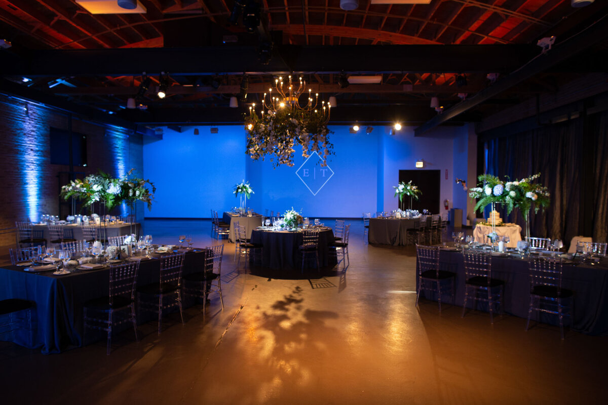 A large room with tables and chairs and a blue wall
