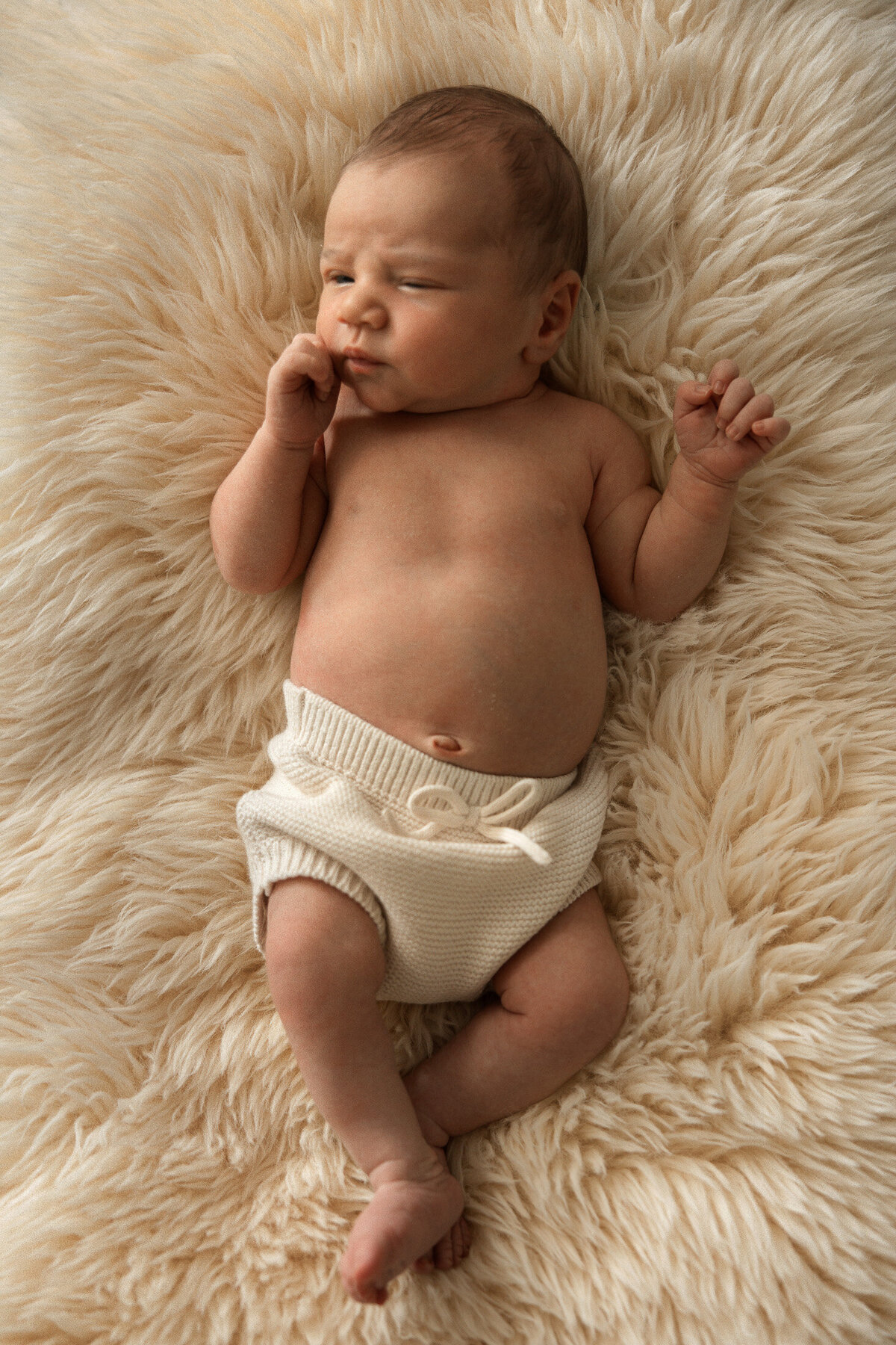 newborn baby on a sheepskin rug