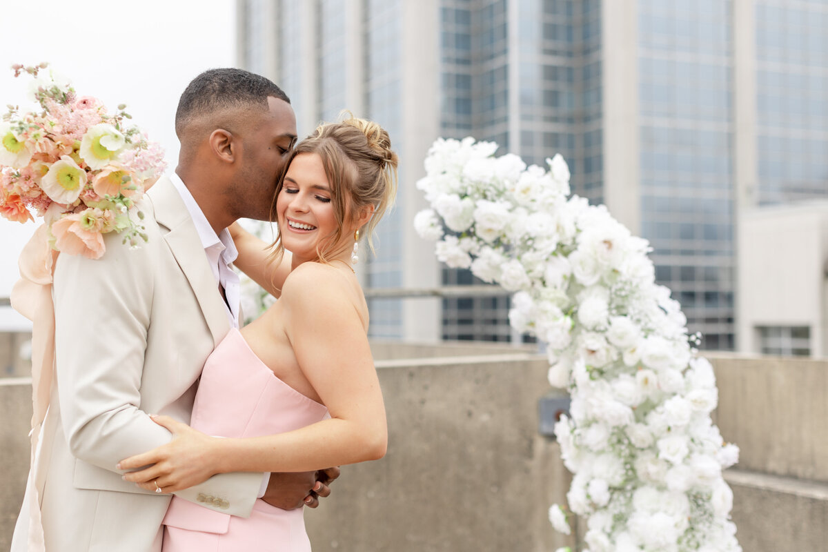Couple posing on rooftop for engagement photos