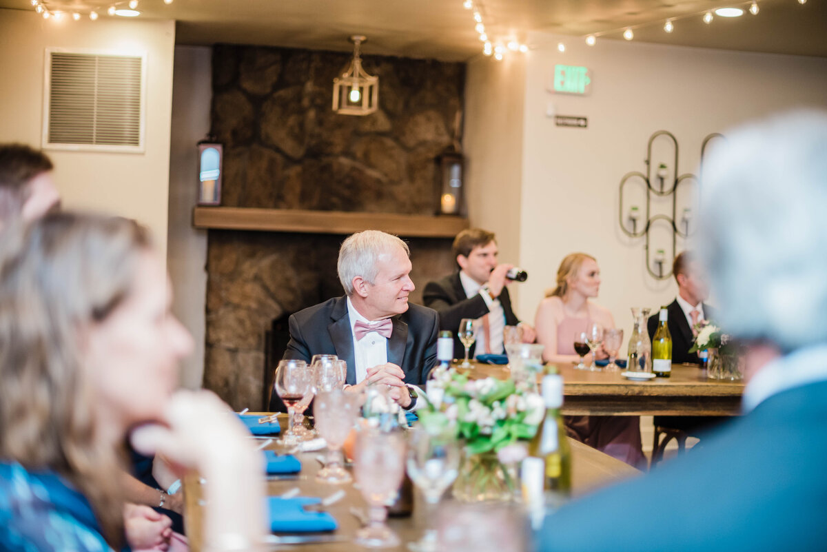 Denver wedding photographer captures a guest watching toasts at a wedding at boulder wedgewood venue