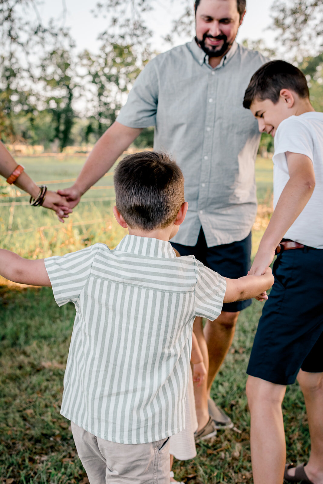 A family holding hands playing ring around the rosy. 