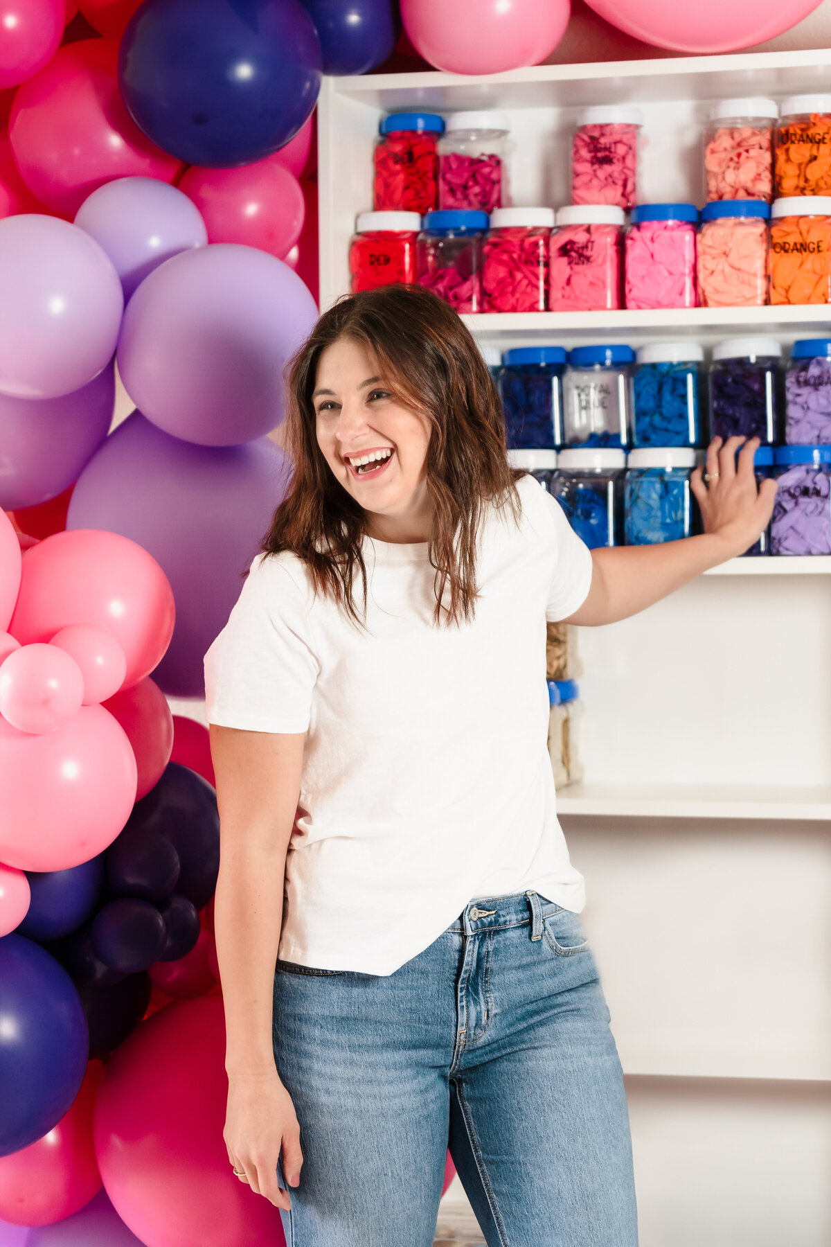 woman organizing a shelf of balloons containers