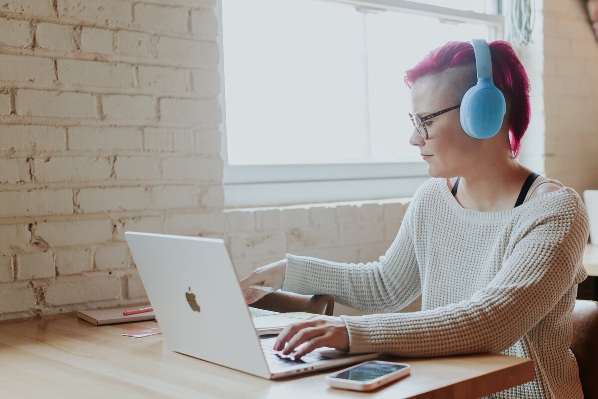 woman-web-designer-wearing-headphones-working-in-coffee-shop-for-brand-session-villa-heights-charlotte