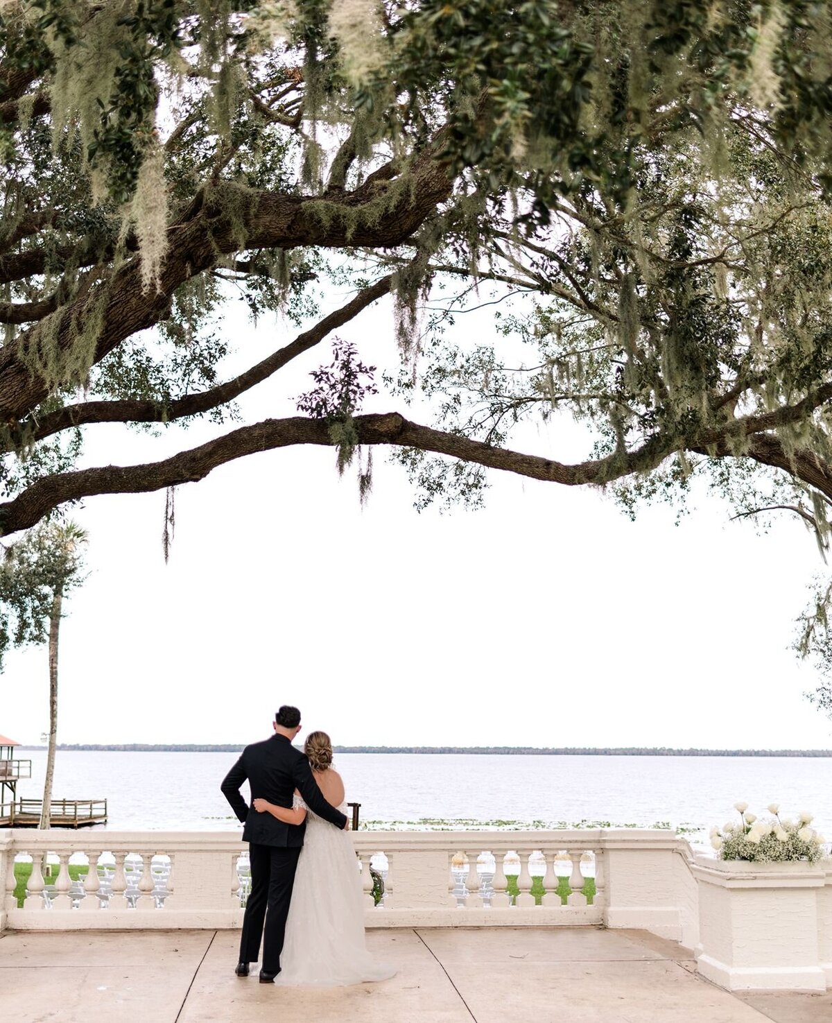 Bride and Groom on terrace looking out across the water at Bella Cosa, Lake Wales, Florida