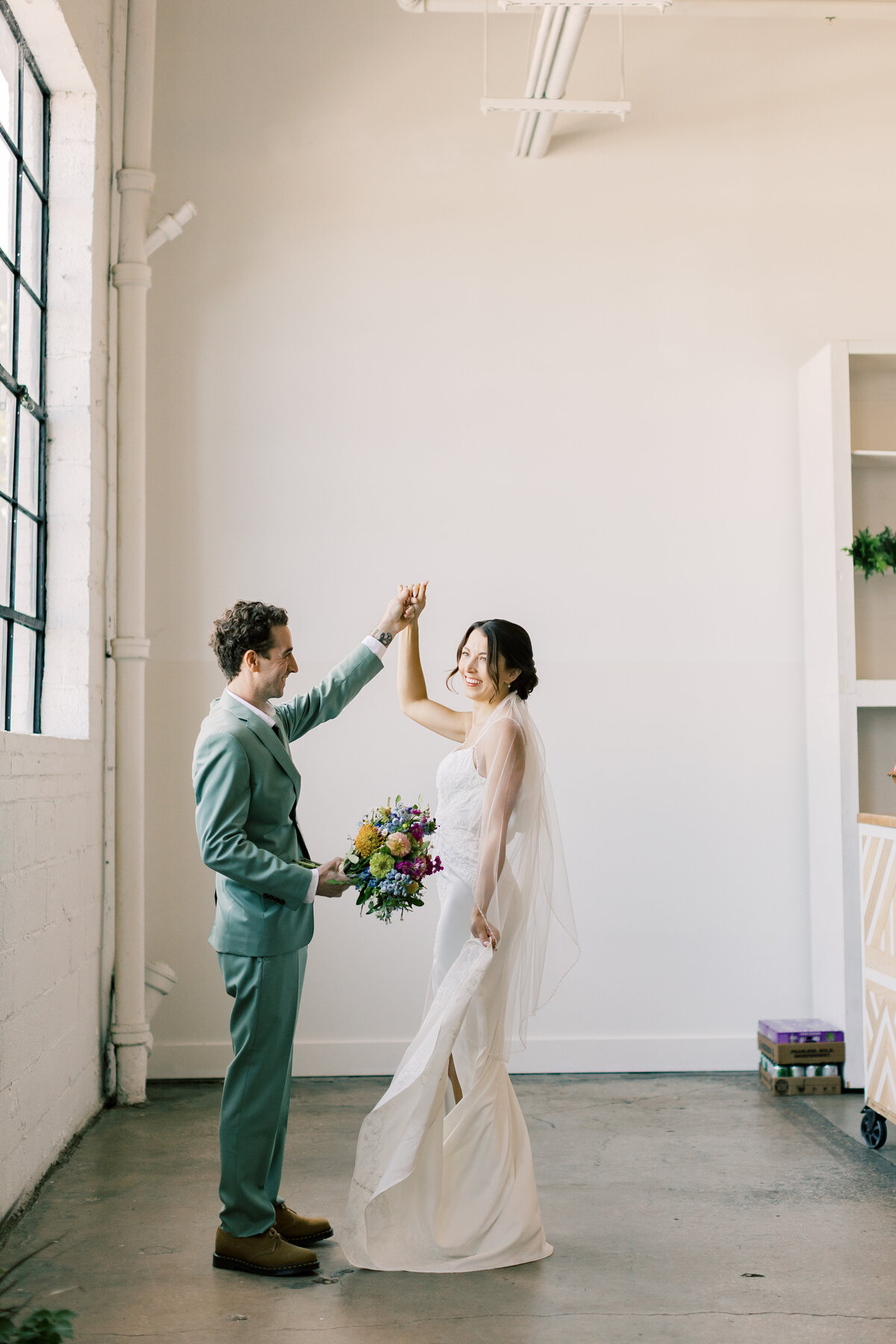 Bride and groom dancing indoors at their modern style industrial wedding
