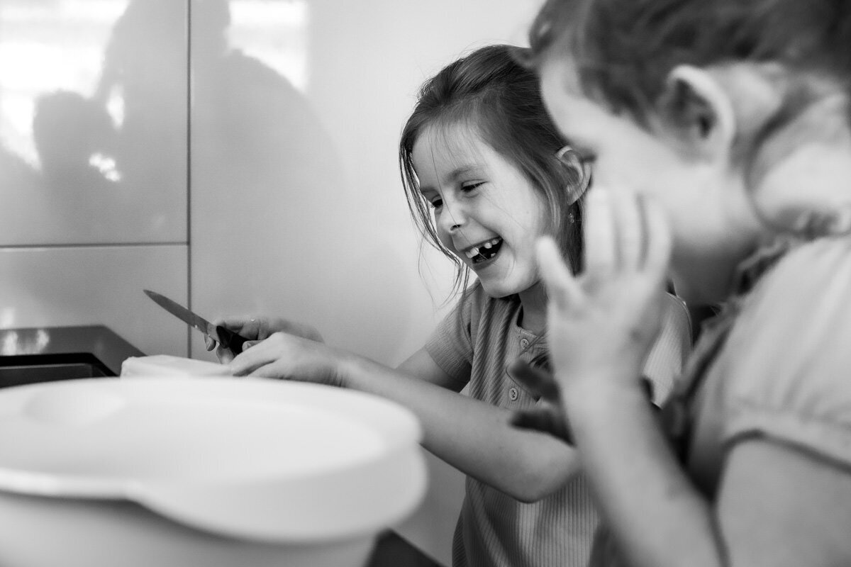 lachende zusjes tijdens bakken taart