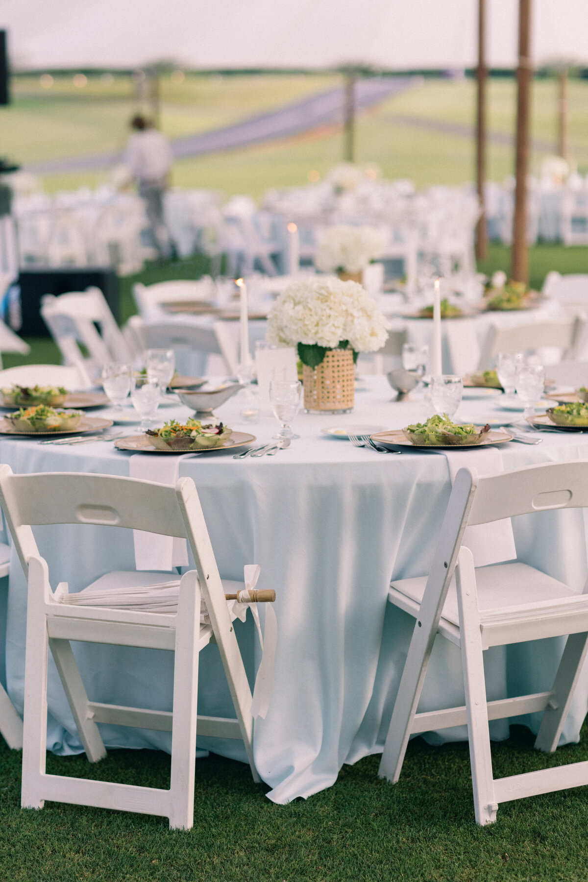 White wedding reception tables with hydrangeas under sailcloth tent