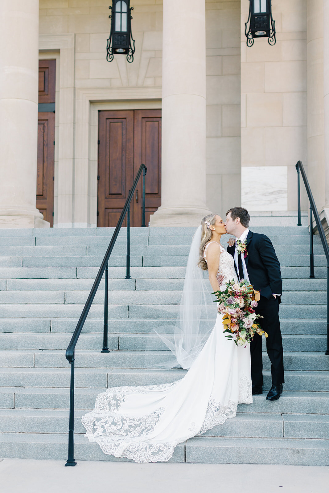 groom-and-bride-kissing-on-church-steps