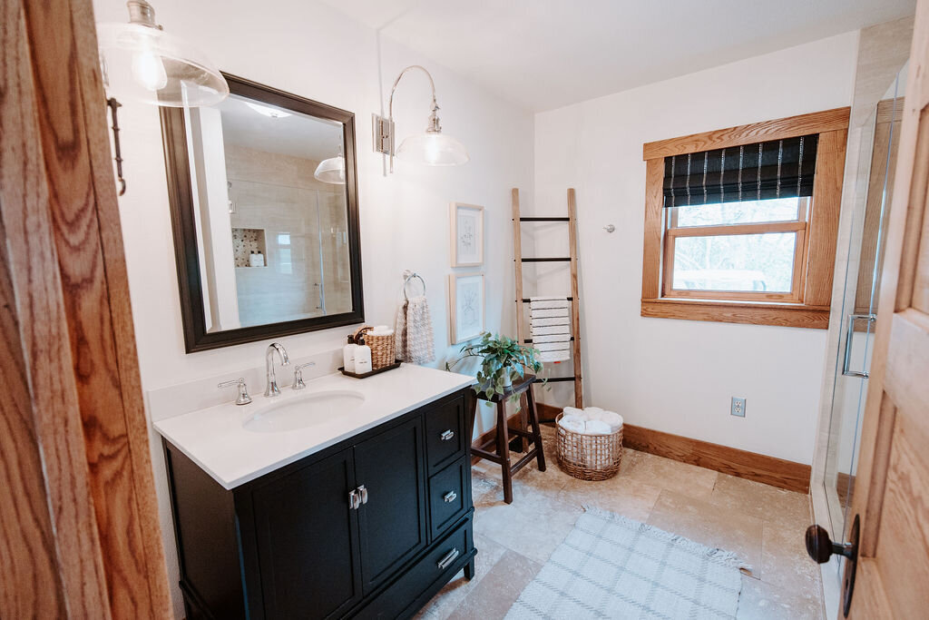 a black vanity in the downstairs bathroom of the modern farmhouse at Willowbrook wedding venue