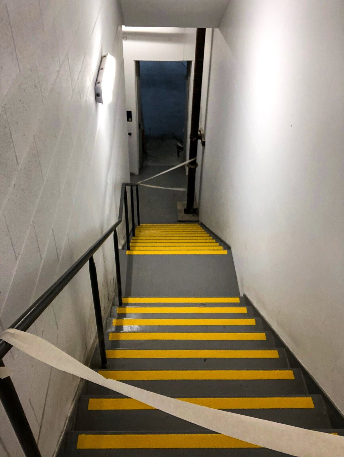 A staircase with yellow and white stripes line marking.