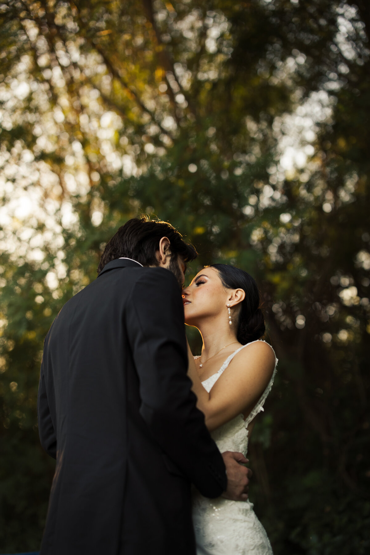 Bride and groom kissing in the trees