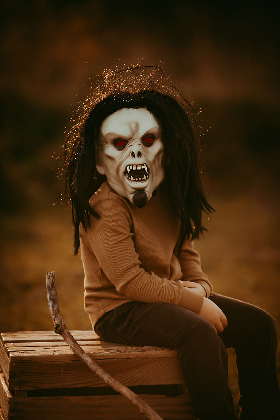 a five year old boy wearing a scary halloween mask at sunset in rochester ny