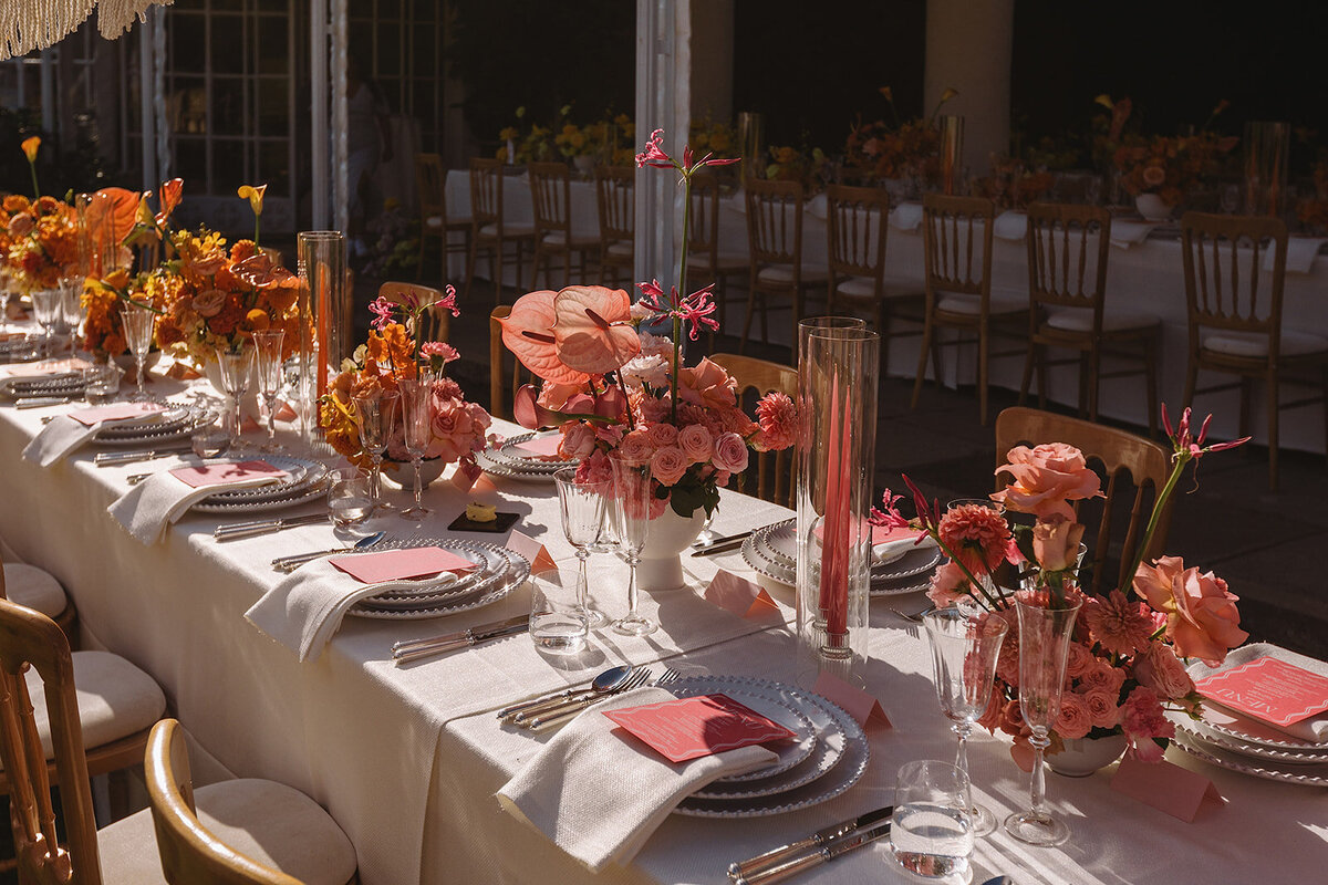 Elegant pink colour block tablescape at an Avington Park wedding, featuring vibrant floral arrangements